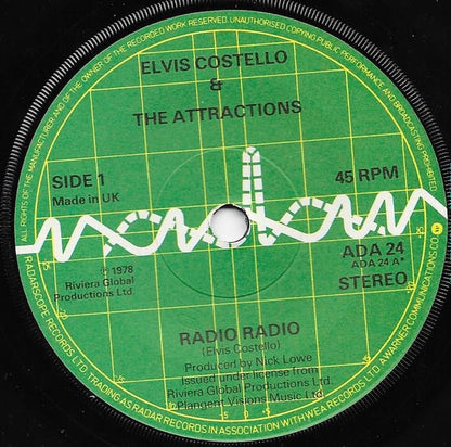 Elvis Costello And The Attractions* : Radio Radio (7", Single, Gre)